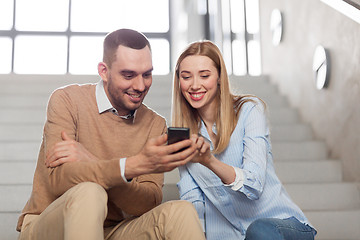 Image showing man and woman with smartphone at office stairs