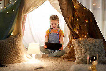 Image showing little girl with tablet pc in kids tent at home