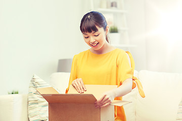 Image showing happy asian young woman with parcel box at home