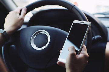 Image showing Woman looking at the screen of the smartphone in the car