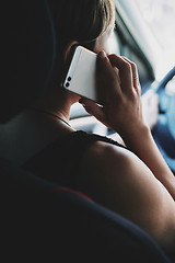 Image showing Woman in the car talking on mobile phone while driving