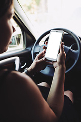 Image showing Woman looking at the screen of the smartphone in the car