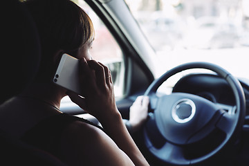 Image showing Woman in the car talking on mobile phone while driving