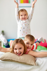 Image showing happy little kids having fun in bed at home