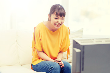 Image showing happy asian young woman watching tv at home