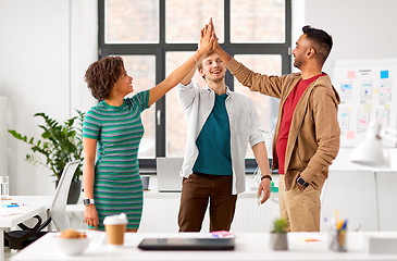 Image showing happy creative team making high five at office