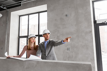 Image showing architects with blueprint and helmets at office