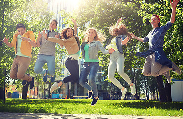 Image showing happy teenage students or friends jumping outdoors