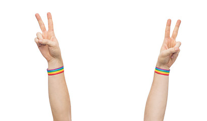 Image showing hands with gay pride rainbow wristbands make peace