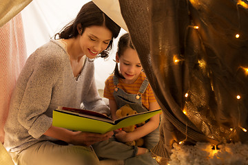 Image showing happy family reading book in kids tent at home