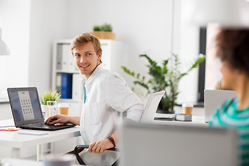 Image showing happy creative workers with laptops at office