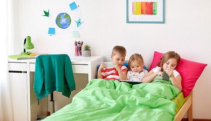 Image showing kids with tablet pc and smartphones in bed at home