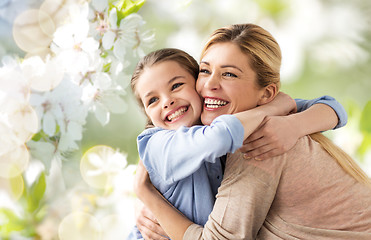 Image showing happy mother hugging daughter over cherry blossom