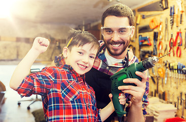 Image showing father and son with drill working at workshop