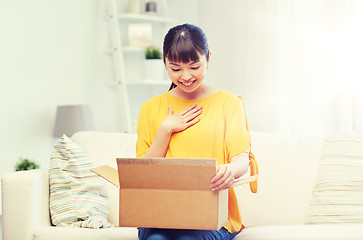 Image showing happy asian young woman with parcel box at home