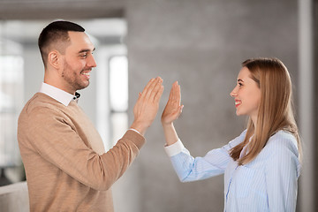 Image showing man and woman making high five at office