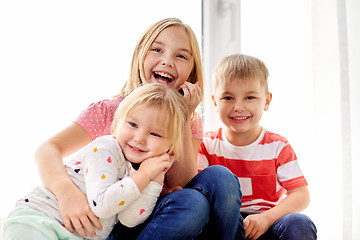 Image showing happy little kids hugging at window