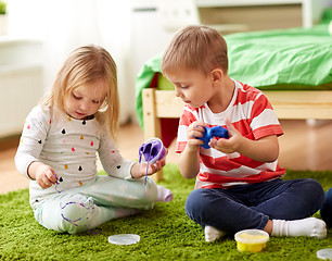 Image showing little kids with modelling clay or slimes at home