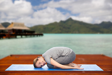Image showing happy woman making yoga in child pose outdoors