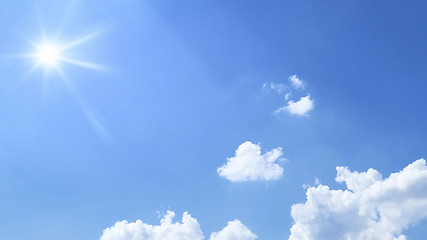 Image showing bright blue sky with sun and clouds background