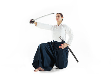 Image showing Aikido master practices defense posture. Healthy lifestyle and sports concept. Woman in white kimono on white background.