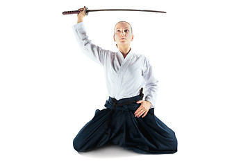 Image showing Aikido master practices defense posture. Healthy lifestyle and sports concept. Woman in white kimono on white background.