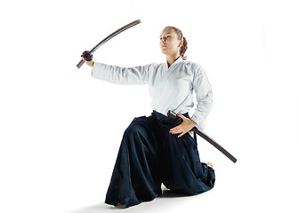 Image showing Aikido master practices defense posture. Healthy lifestyle and sports concept. Woman in white kimono on white background.