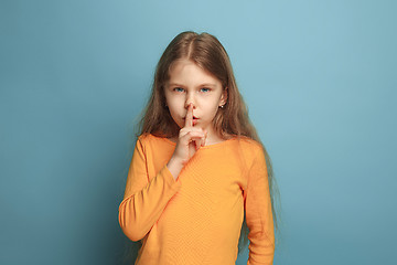 Image showing The call for silence. Teen girl on a blue background. Facial expressions and people emotions concept