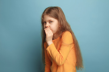 Image showing The secret. The teen girl on a blue studio background. Facial expressions and people emotions concept.