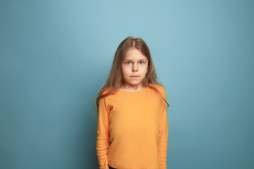 Image showing The serious teen girl on a blue background. Facial expressions and people emotions concept