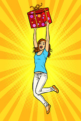 Image showing Joyful young woman jumping up with a gift