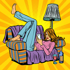 Image showing Woman lying on the couch and reading smartphone