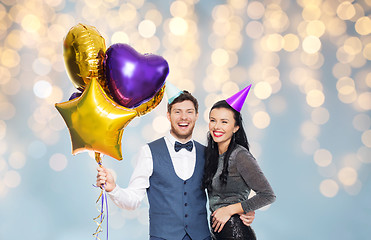 Image showing couple with party caps and balloons over lights