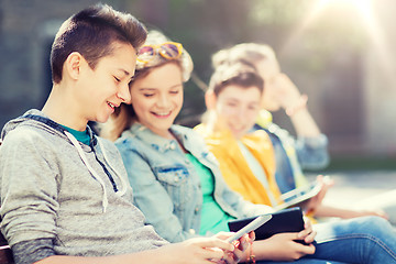 Image showing happy teenage friends with tablet pc outdoors