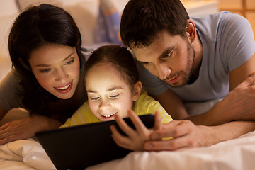 Image showing family with tablet pc in bed at night at home