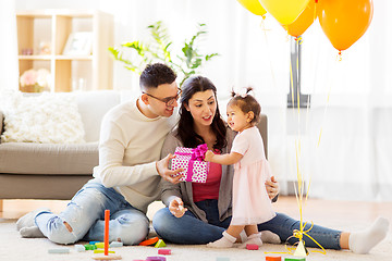 Image showing baby girl with birthday gift and parents at home 