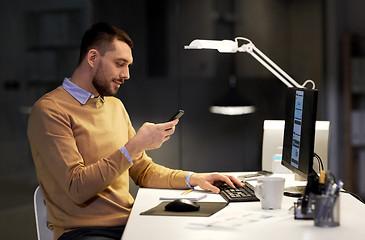 Image showing man with smartphone working late at night office