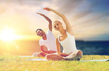 Image showing couple making yoga exercises outdoors