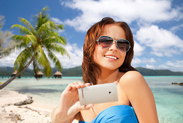 Image showing woman taking selfie by smartphone on beach
