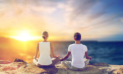 Image showing happy couple making yoga and meditating outdoors