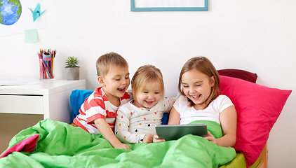 Image showing little kids with tablet pc in bed at home