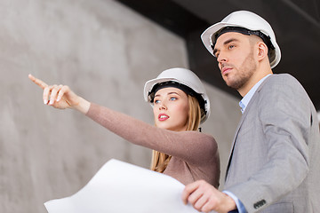 Image showing architects in helmets with blueprint