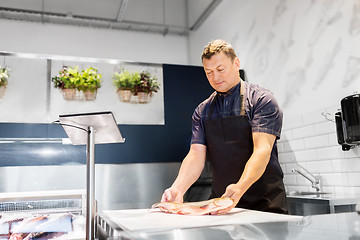 Image showing seller weighing fish on scale at seafood shop