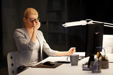 Image showing tired businesswoman working at night office