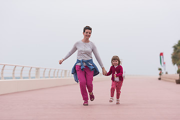 Image showing mother and cute little girl on the promenade by the sea