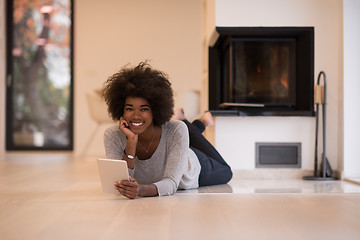 Image showing black women using tablet computer on the floor