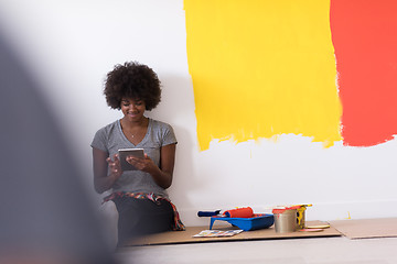 Image showing back female painter sitting on floor