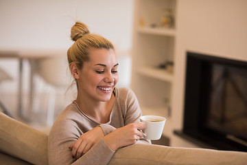 Image showing woman with a mug near a fireplace