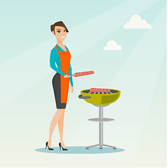 Image showing Woman cooking steak on barbecue grill.