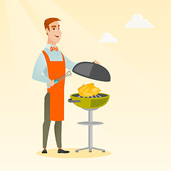 Image showing Man cooking chicken on barbecue grill.